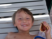 August 2006 Photos: Alex lounging by the pool with a hot dog.