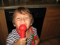 September 2006 Photos: Alex singing into a tinker toy mic he made.