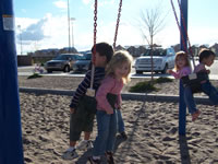 March 2007: Alex and Ashlyn, Max and Peyton sharing rides in the bucket swings.