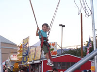 Sept 2007: Alex loved this 'ride' at the State Fair. It was a harness attached to bungee cords atop a huge inflatable bouncer. He jumped and jumped and could really go up high. So fun to watch him soar!