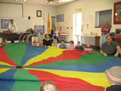 March 2008: Playing parachute with the kids at TJ's party. Alex is in the Spiderman shirt.